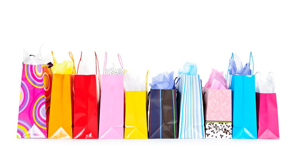 Row of colorful shopping bags isolated on white background